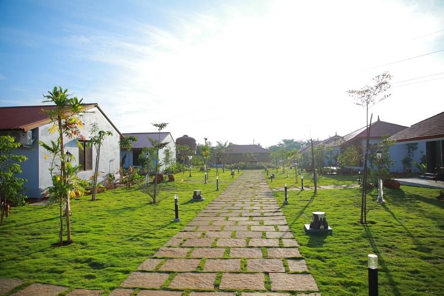 Stone pathway leading to the villas in the Villa block with lawns at GK Hill View Resort