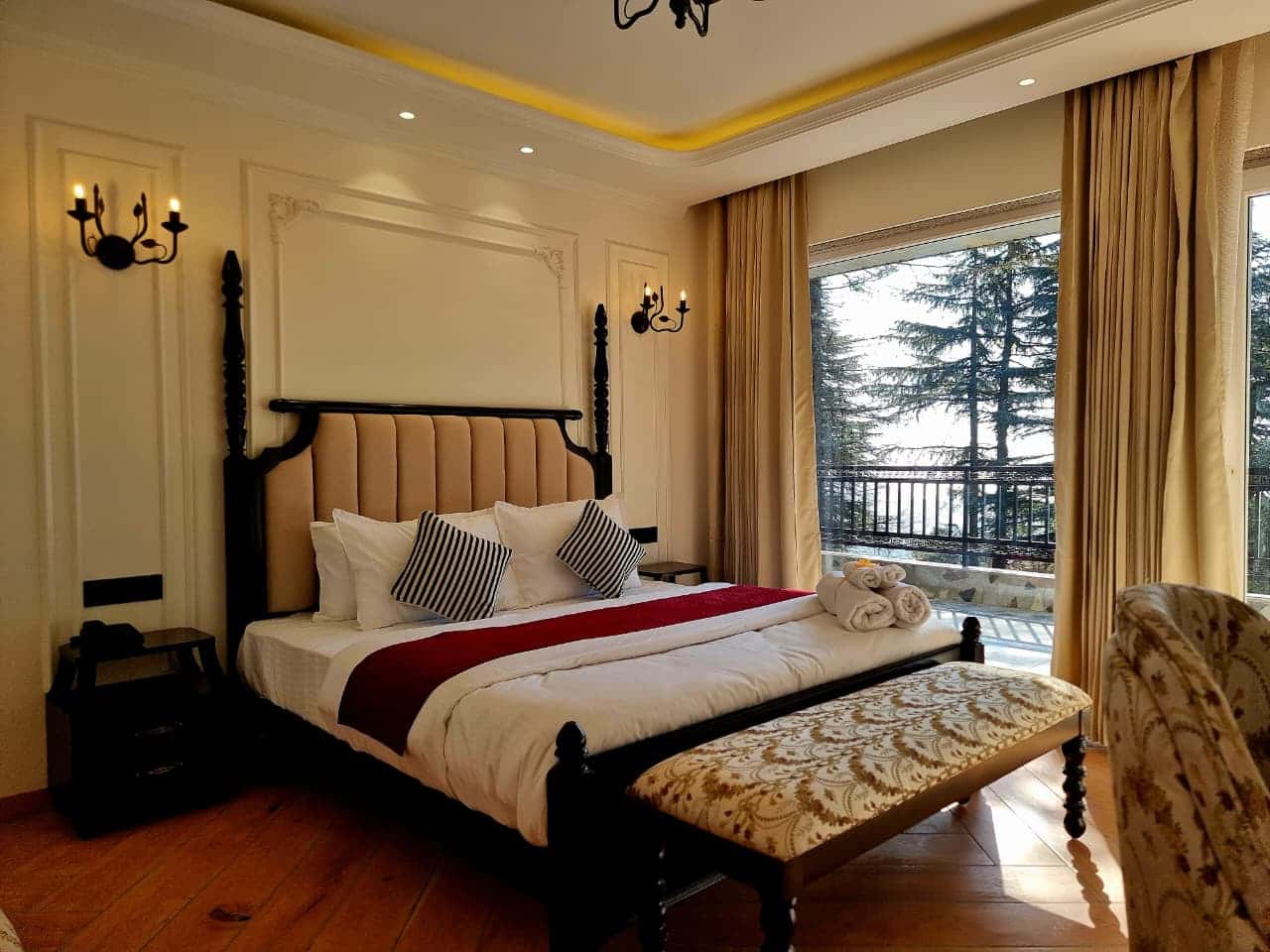 Executive Room at Akasa Dalhousie, king bed with open balcony door and pine tree mountain valley views