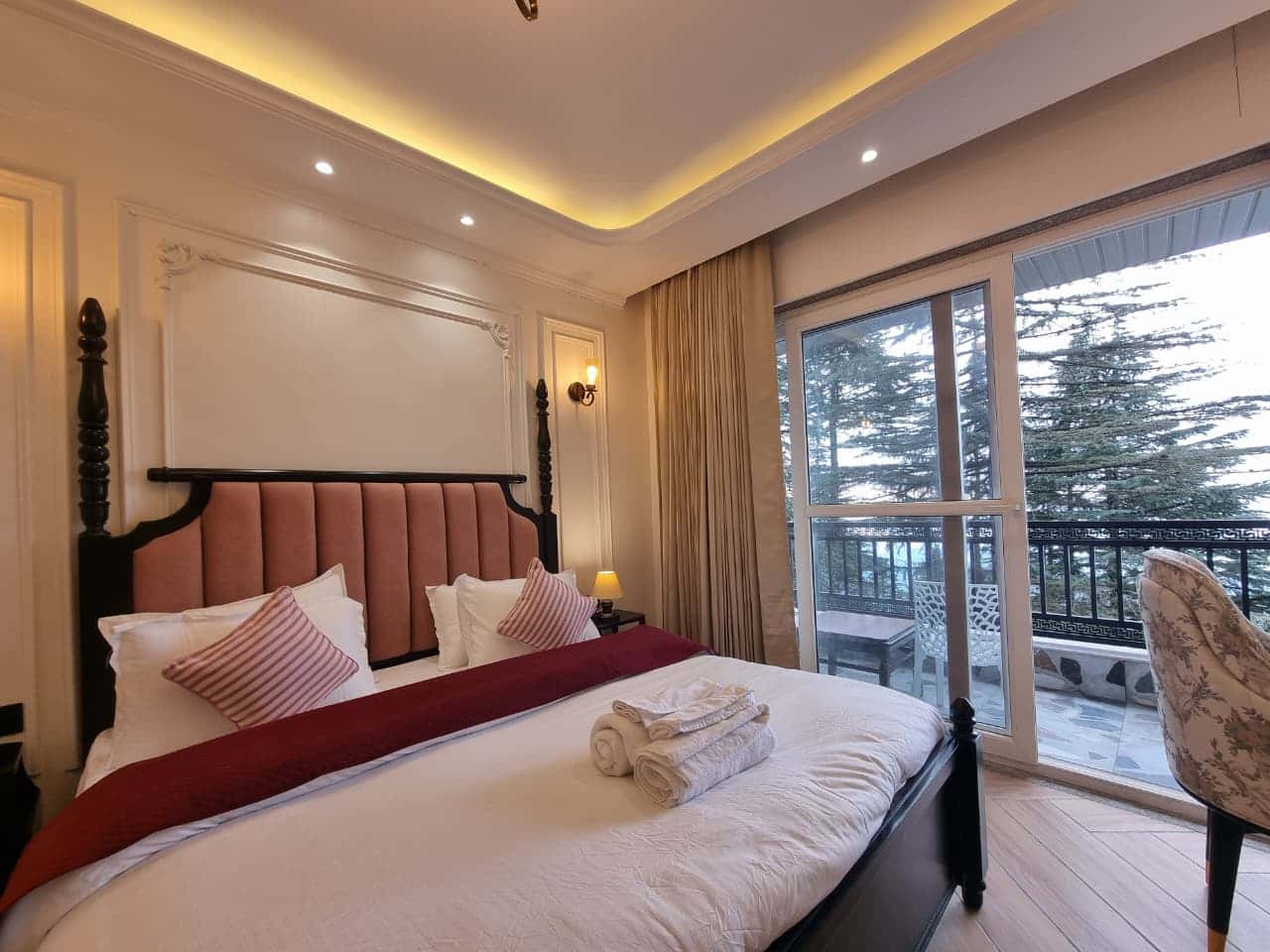 Club Room at Akasa Dalhousie, luxury king bedroom with four-poster bed and elegant wall sconces