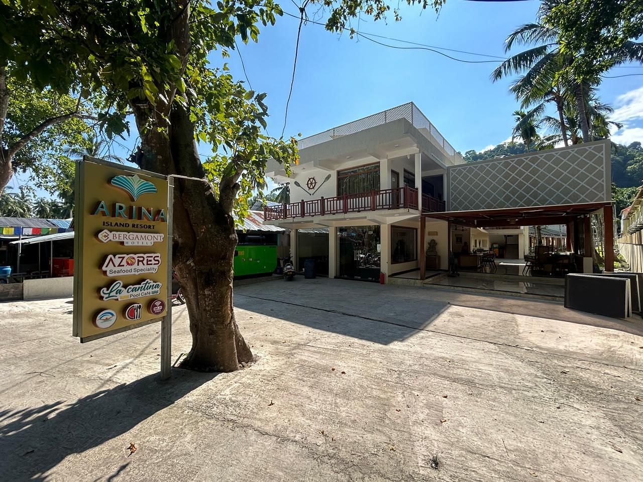 Image of the front yard at the resort during a sunny day featuring the facade  and trees all around | Arina Island Resort