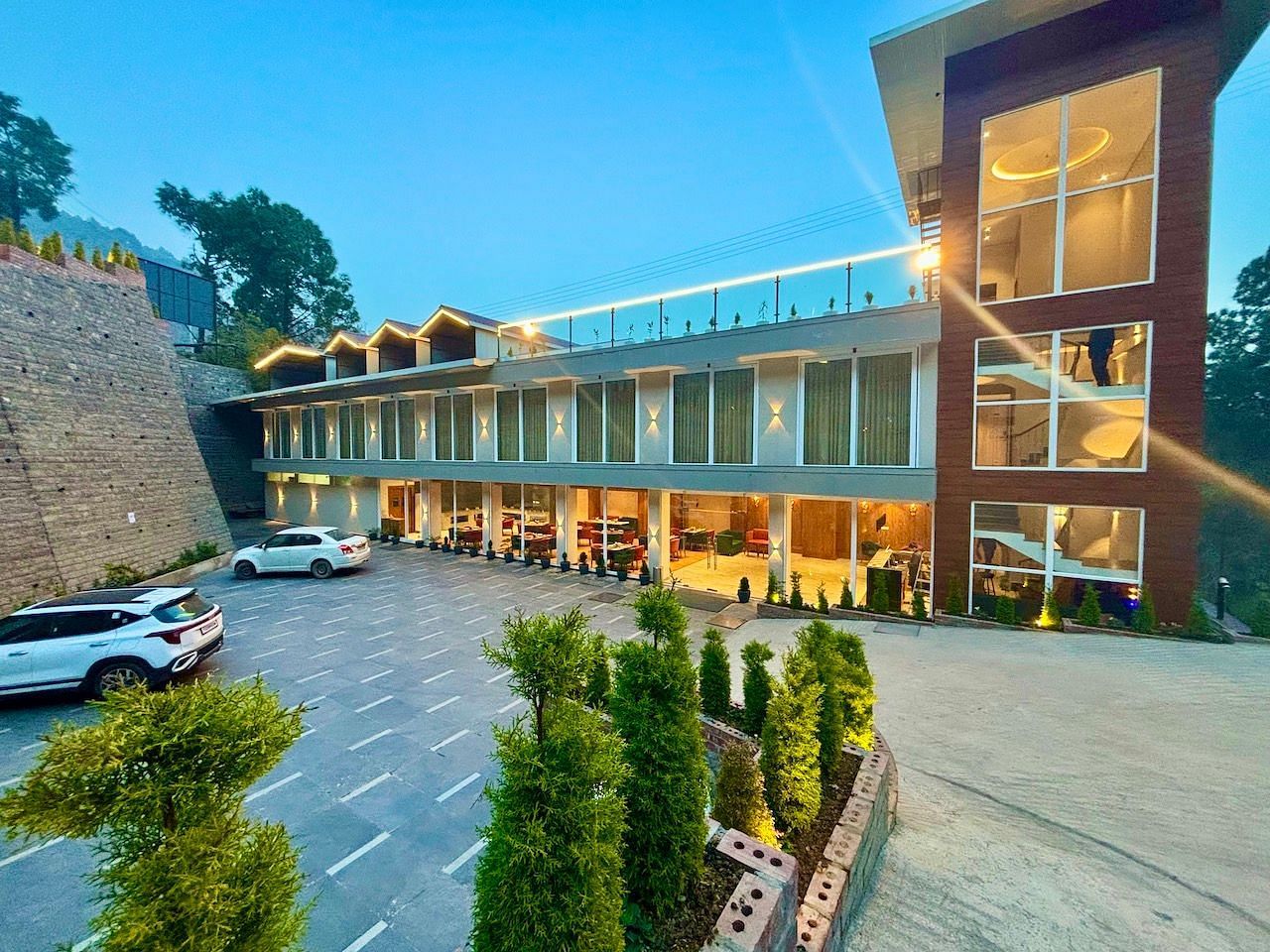Exterior view of the ARNISA Boutique Hotel building with glass facade and neatly landscaped driveway