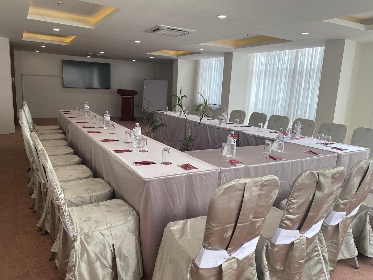 A banquet hall, windows with curtains and TV