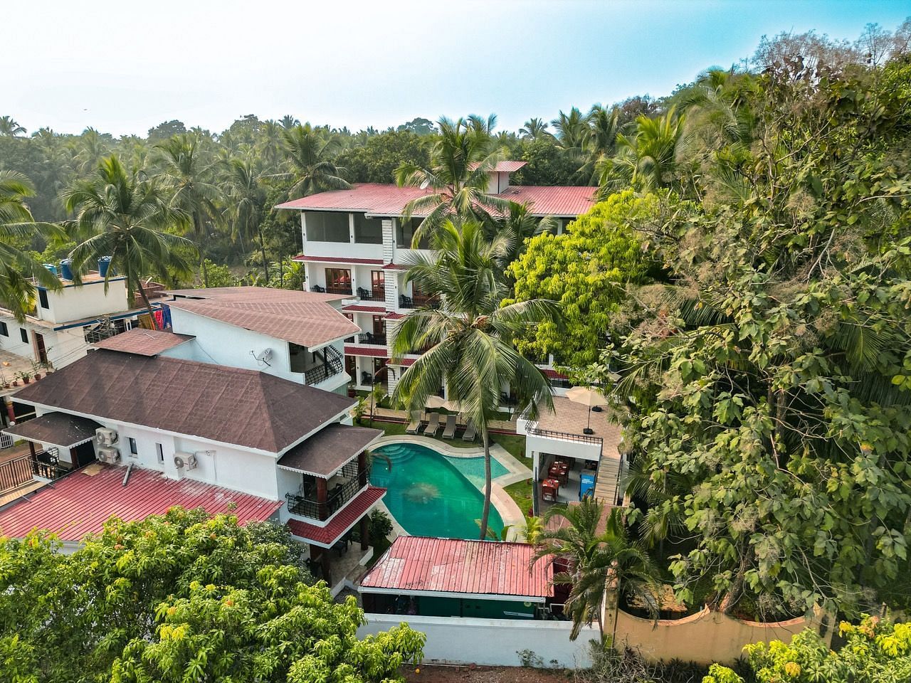 An aerial view of  The Verda de Miranda Resort with a pool nestled among palm trees.