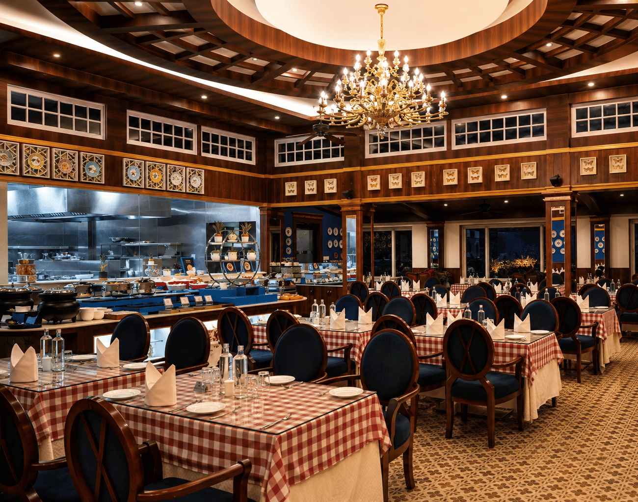 Tiffany restaurant with red-and-white chequered tablecloths, blue high-back chairs, an open live kitchen and a chandelier at MAYFAIR Himalayan Spa Resort, Kalimpong.