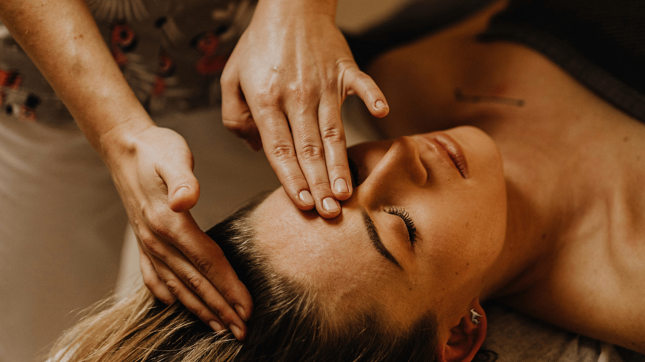 A woman receiving a forehead massage in a spa.