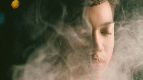 A calm face enveloped in mist, eyes closed, with a tranquil expression.