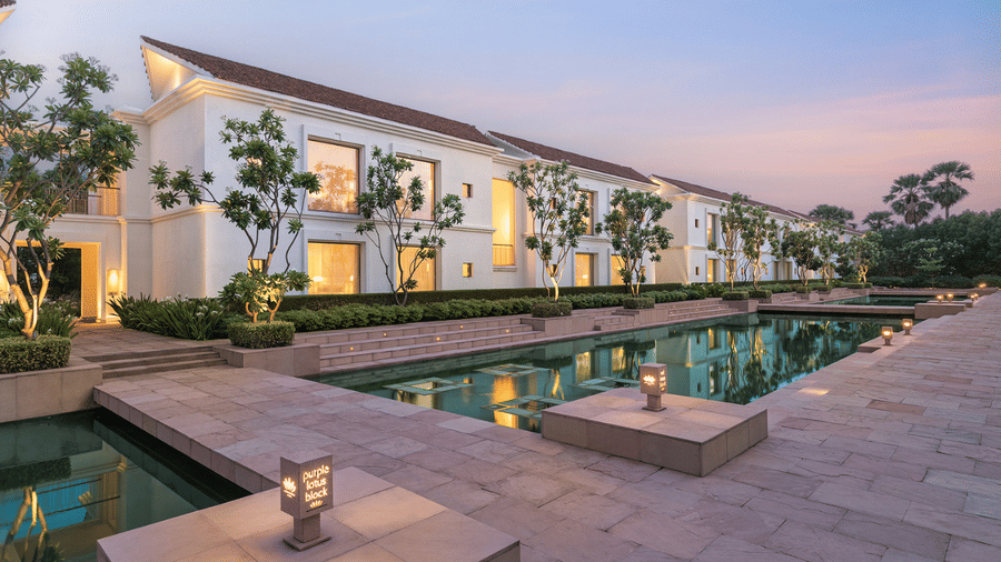 Elegant exterior view of the Purple Lotus Block at dusk, with warm lighting, tranquil water features, and lush greenery - Marasa Sarovar Premiere, Bodhgaya