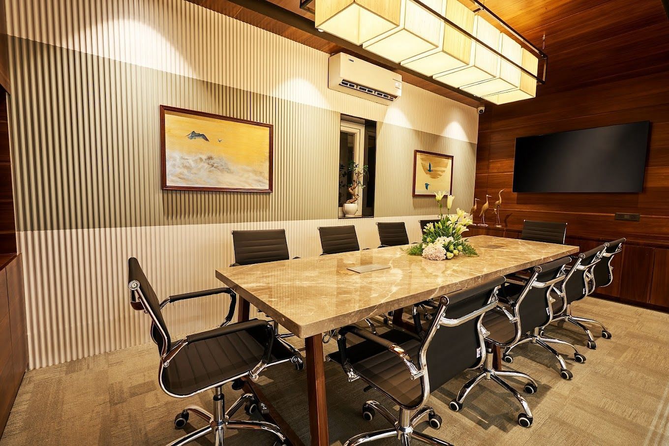 A conference room setting with a centre table and black chairs around it at the boardroom at Visthara - Urban Boutique Hotel