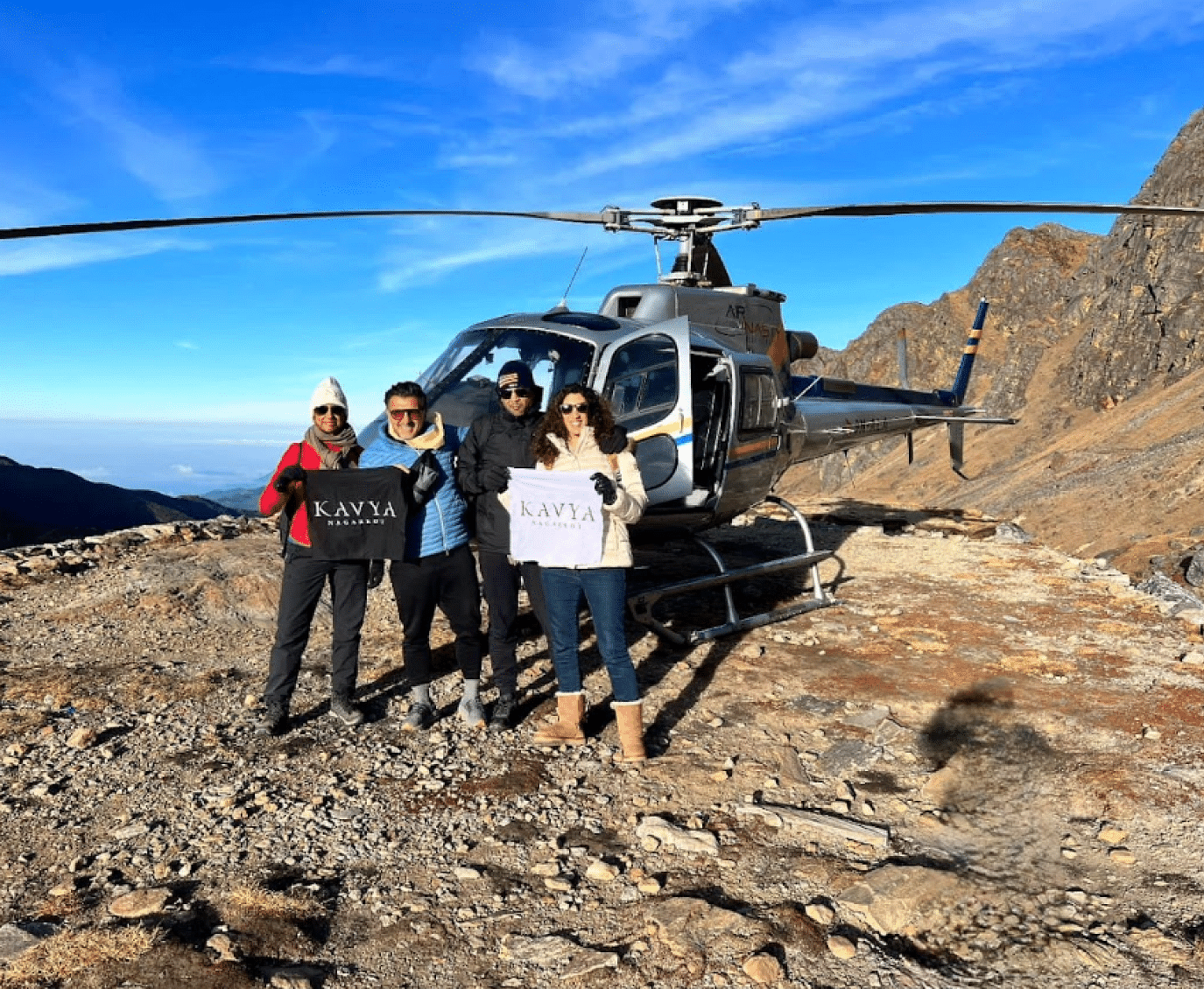 A group of people posing in front of a parked helicopter at the hill | Kavya Resort and Spa, Nagarkot