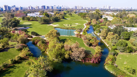 Aerial view of a golf course and surrounding trees at Karma Lakelands.