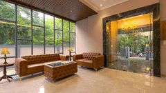 Lobby at Magnus Nexstar Suites, Kalyani Nagar featuring a spacious lobby with sofa set and centre table for guests. The entrance and the wall is made with glass making it transparent, giving a view of outside world.