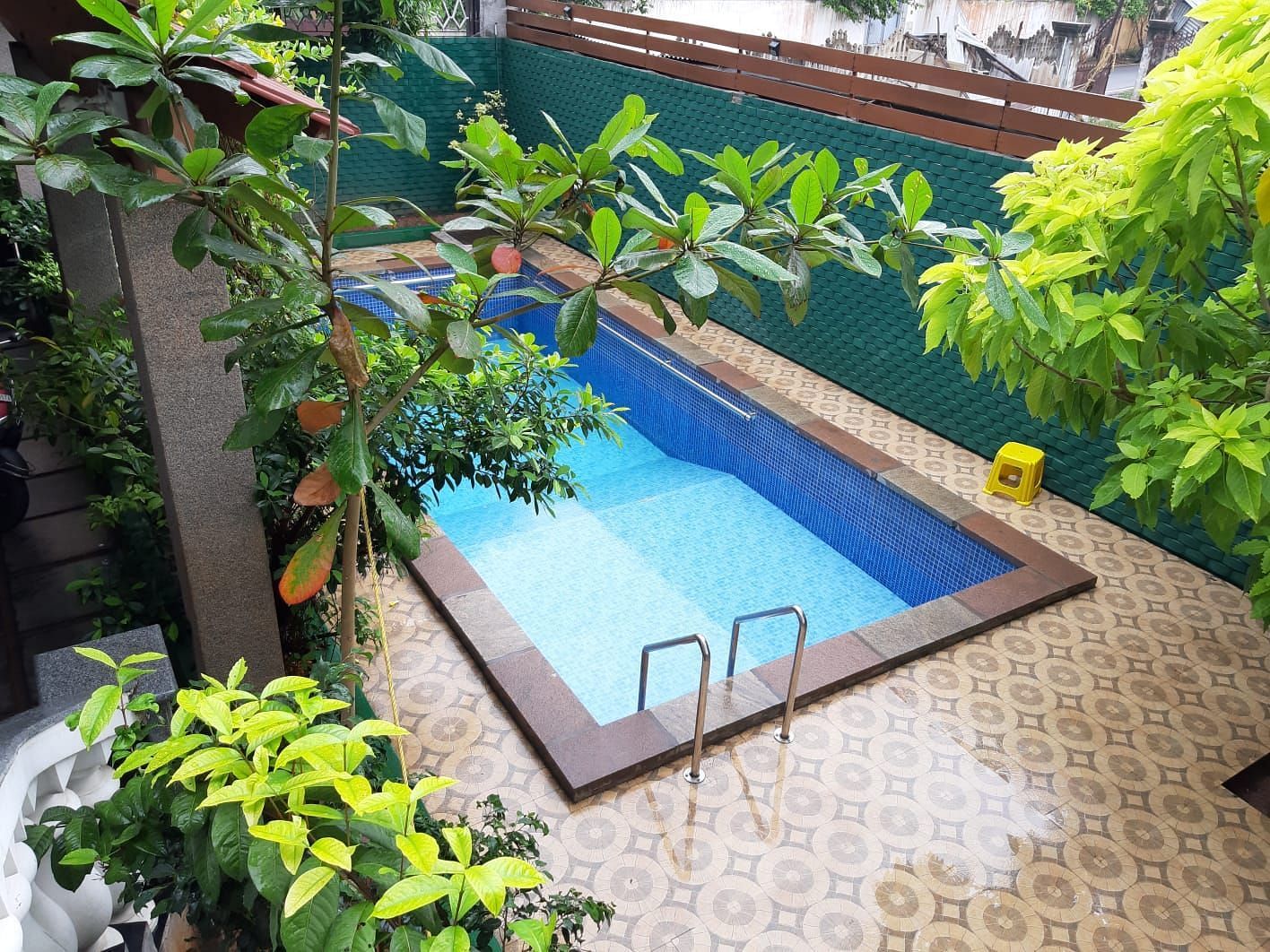 Image of a an outdoor swimming pool with trees on the side at Villa Serenity Le Sejour Pondicherry.