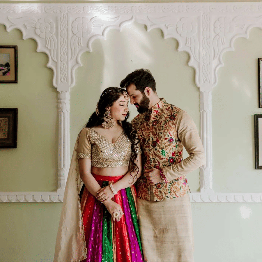 Bride and groom posing indoors in traditional attire during a wedding photoshoot.