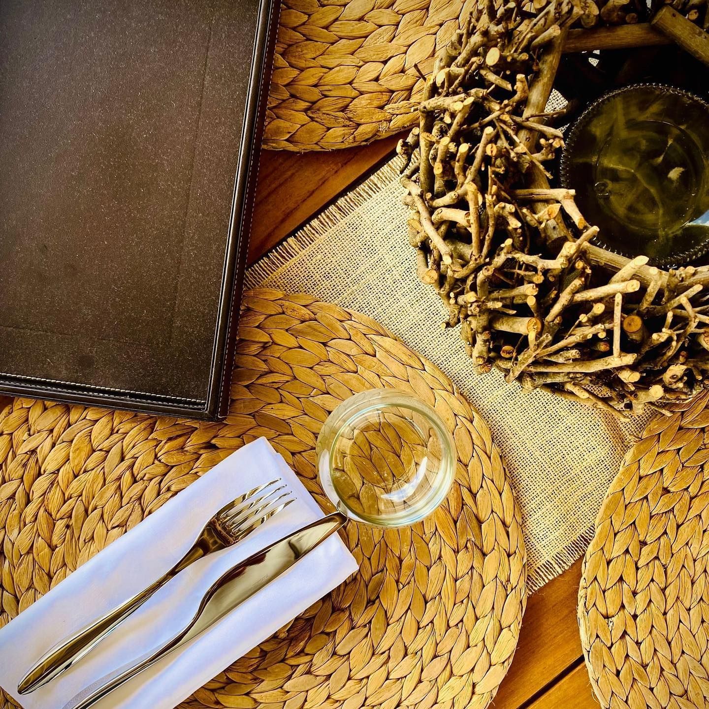 Table setting with a glass, napkin-wrapped cutlery, and menu at Tamarind Hills Resort and Villas, Antigua.