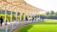 Driving Range at Karma Lakelands with a covered practice area and lush green fairway,  it is accessible with a Delhi Golf Course Membership.