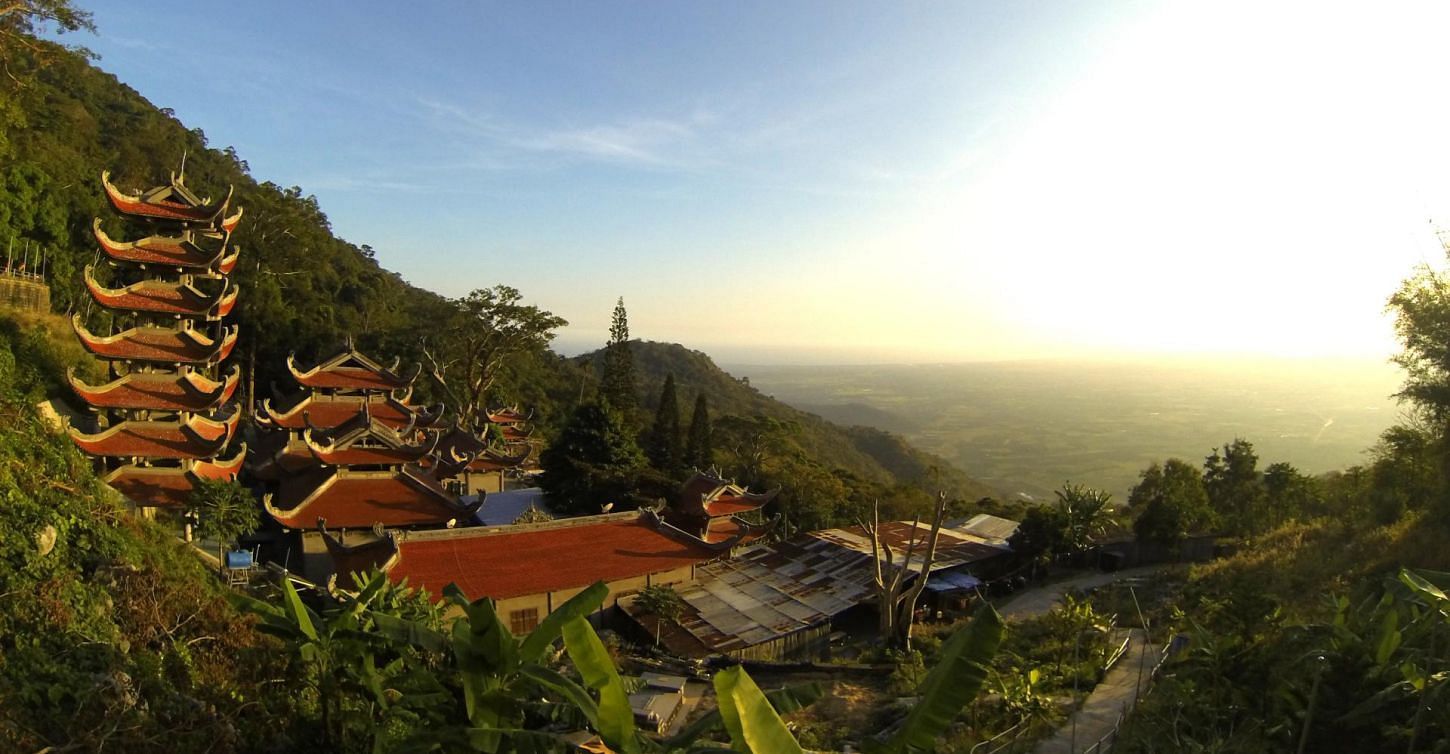Aerial view of buildings with traditional South East Asian architecture surrounded by greenery