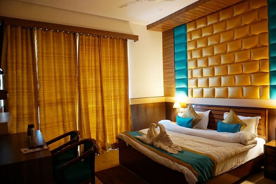 Double Bed Premium room with blue and white bed covers at Hotel Panchvati Inn, Joshimath