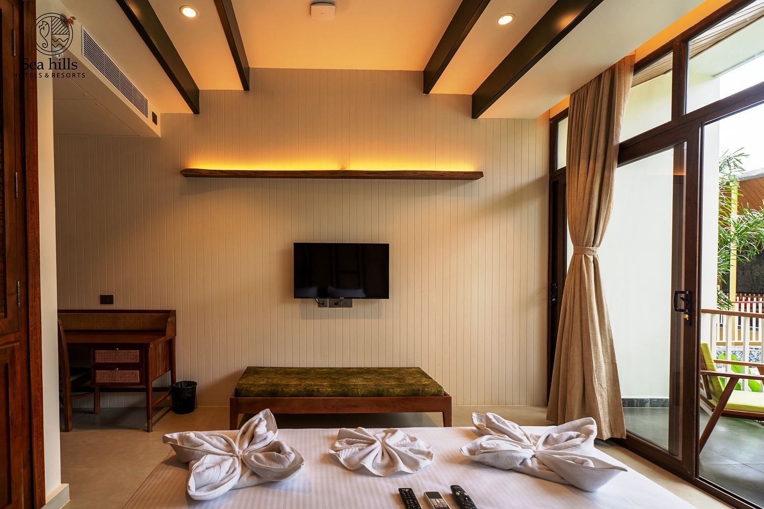 Spacious bedroom with large windows, wooden furniture, and fresh linens, providing a serene environment - Sea Hills Resort, Swaraj Dweep (Havelock)