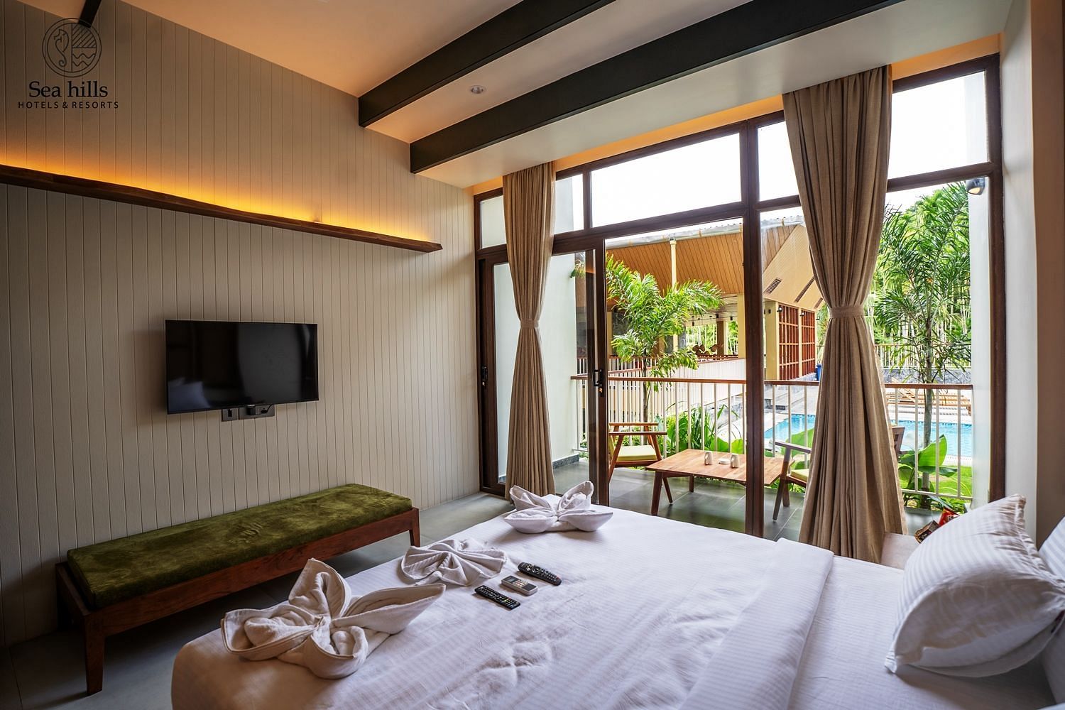 Spacious bedroom with large windows offering a view of the outdoors, complemented by modern wooden furnishings - Sea Hills Resort, Swaraj Dweep (Havelock)