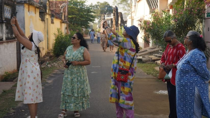 A group of women looking and taking pictures of an old building during their Activities in Chettinad via Chidambara Vilas. 