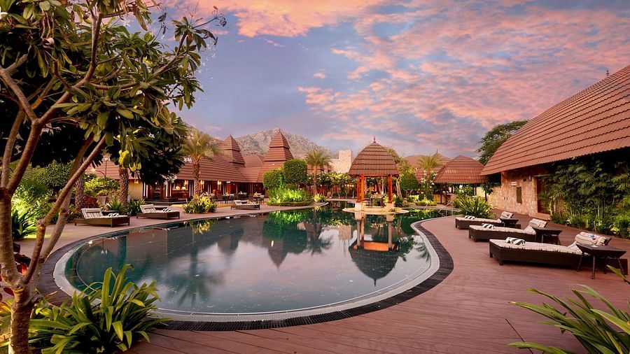 A panorama showing the entire Pushkar resort with swimming pool and the cottages under a dusky sky 