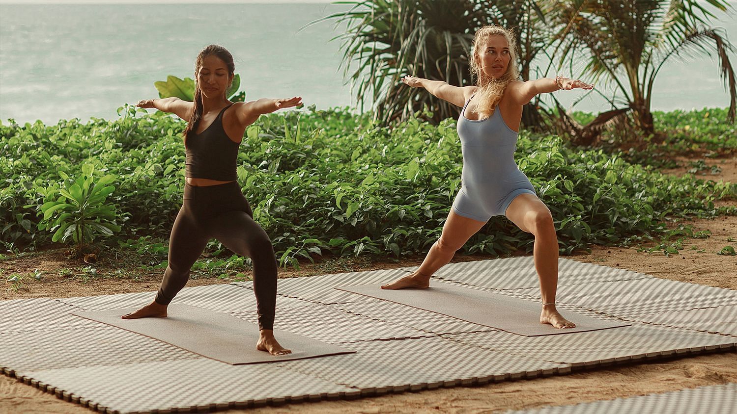 Two women in warrior pose on yoga mats surrounded by greenery - Maikhao Dream Villa Resort & Spa, Phuket