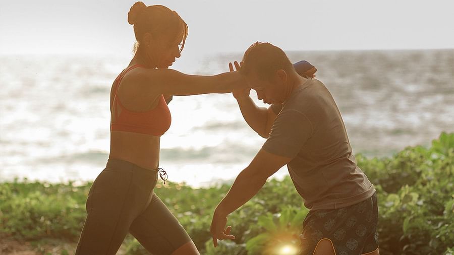 Woman in sportswear practising self-defence with a male partner near the sea - Maikhao Dream Villa Resort & Spa, Phuket