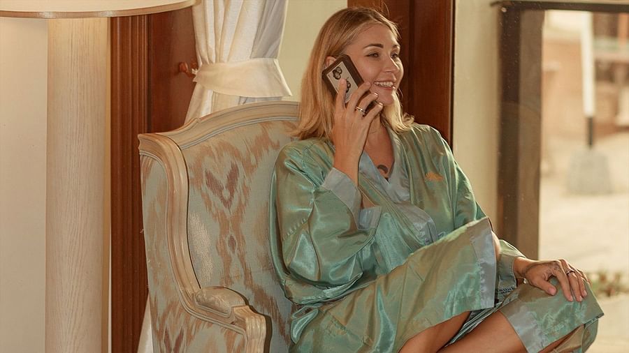 Smiling woman in a silk robe talking on a mobile phone by a window - Maikhao Dream Villa Resort & Spa, Phuket