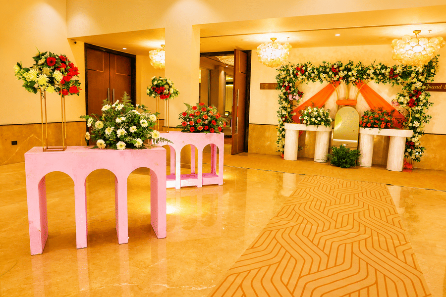 The banquet hall pre-function area with a floral stage backdrop and decorative event setup at Ambrosia Sarovar Portico, Haridwar.