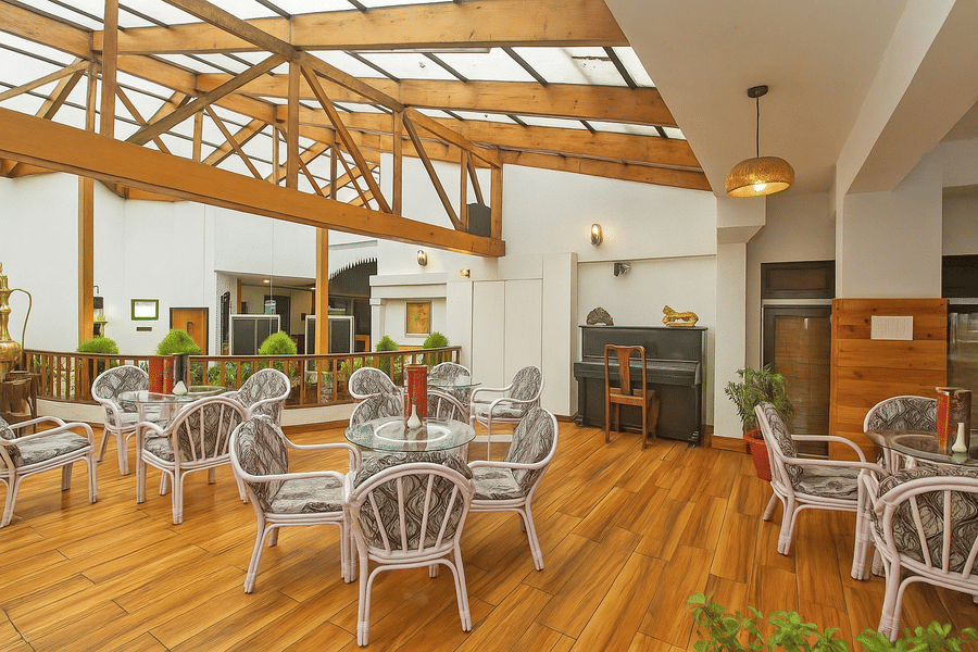 Sunset Bar and Lounge at Central Heritage Resort and Spa, Darjeeling featuring several sets of table and chairs