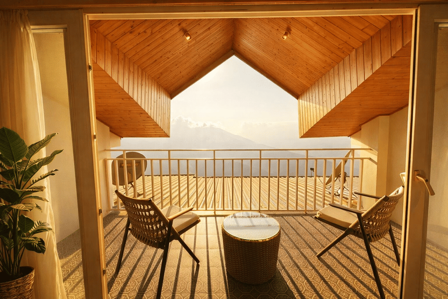 Room with balcony at Pride Premier Darjeeling featuring two chairs and a centre table facing towards the mountain view.