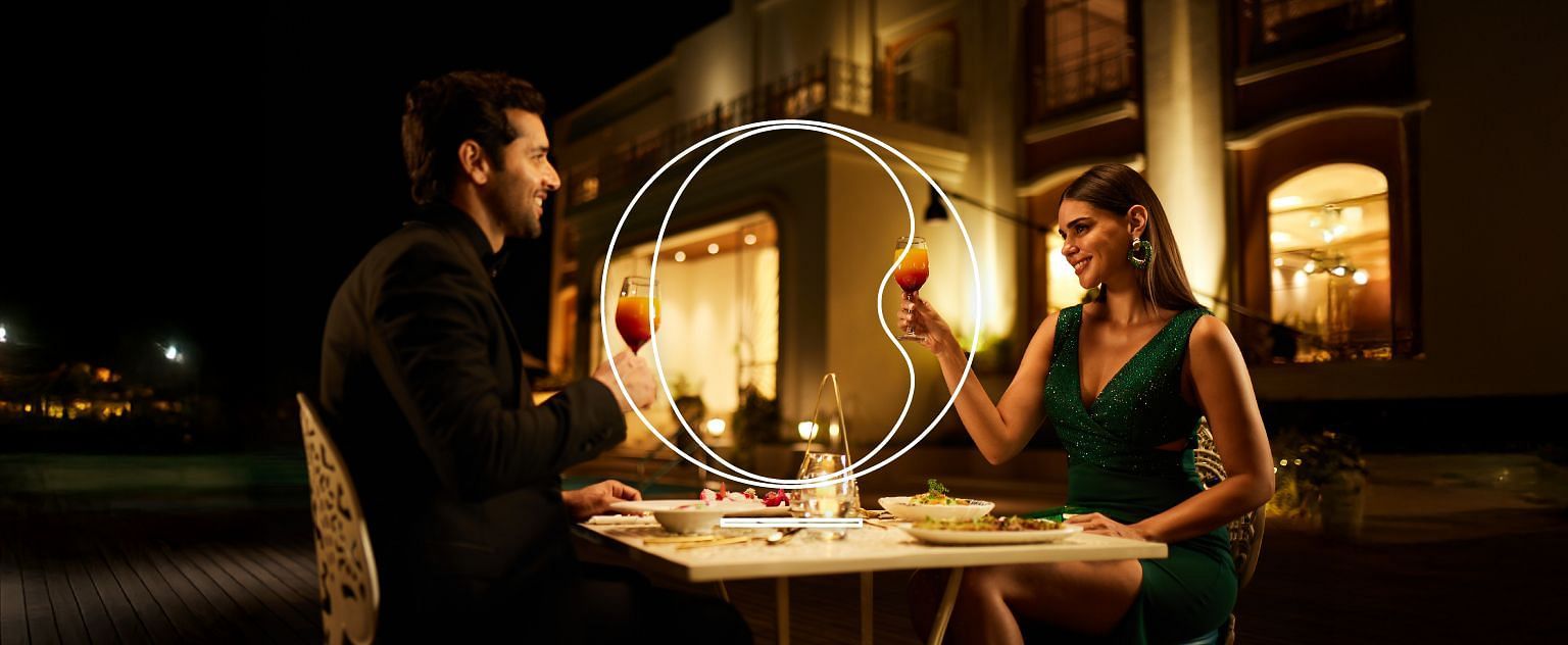 A couple having a candle-lit dinner as they are about to clink their wine glasses at the Miros.