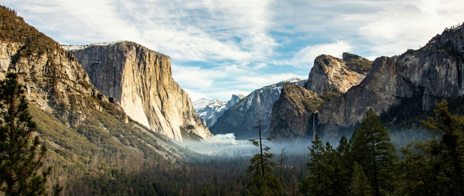 A wide angle view of Yosemite National Park with mountains in the distance.