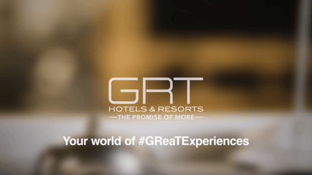 Banner featuring the GRT Hotels & Resorts logo with the tagline ‘Your world of #GReaTExperiences’, set against a soft, blurred background in warm, neutral tones.