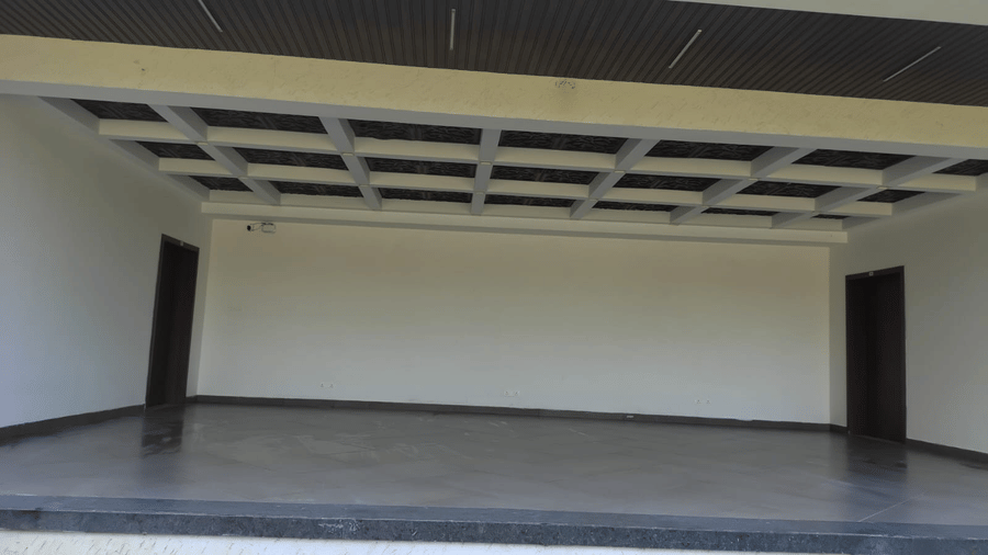 Event stage with covered ceiling structure located outside the Standard Room area at Cholaa Dynasty, Kumbakonam, used for functions and gatherings.