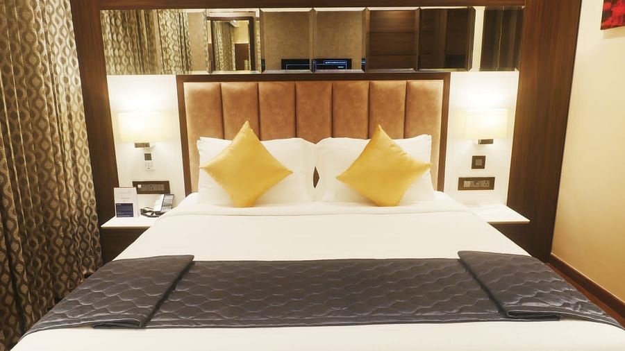 A front view of the Premium king  with aplushy bed and a table lamp.