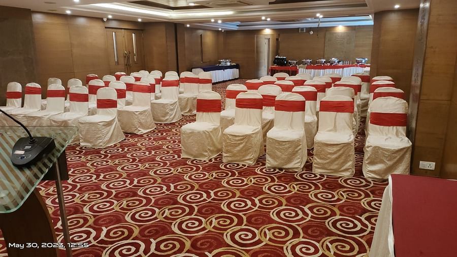 An event space in a hotel with banquet seating and decorative carpet.- The President Hotel Jayanagar, Bangalore