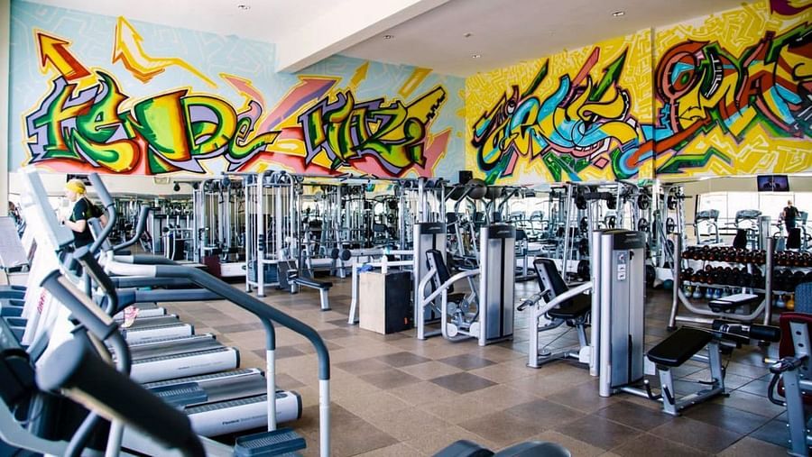 Gym area with treadmills, weight machines and bright graffiti mural behind at The Boma Nairobi.