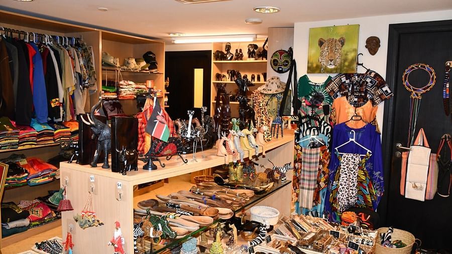 Well stocked gift shop displaying souvenirs, clothes, and crafts on shelves and racks at The Boma Nairobi.