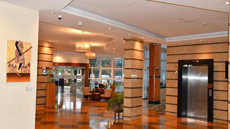 Spacious, sleek lobby or corridor with seating and polished wood flooring at The Boma Nairobi.