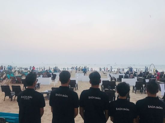 5 hotel team members standing side by side, facing behind looking at the beach | Amara Oceanfront Resort, Baga,