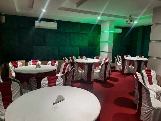 An event hall featuring well decorated tables and chairs - Mysore Gate Hotel Bangalore