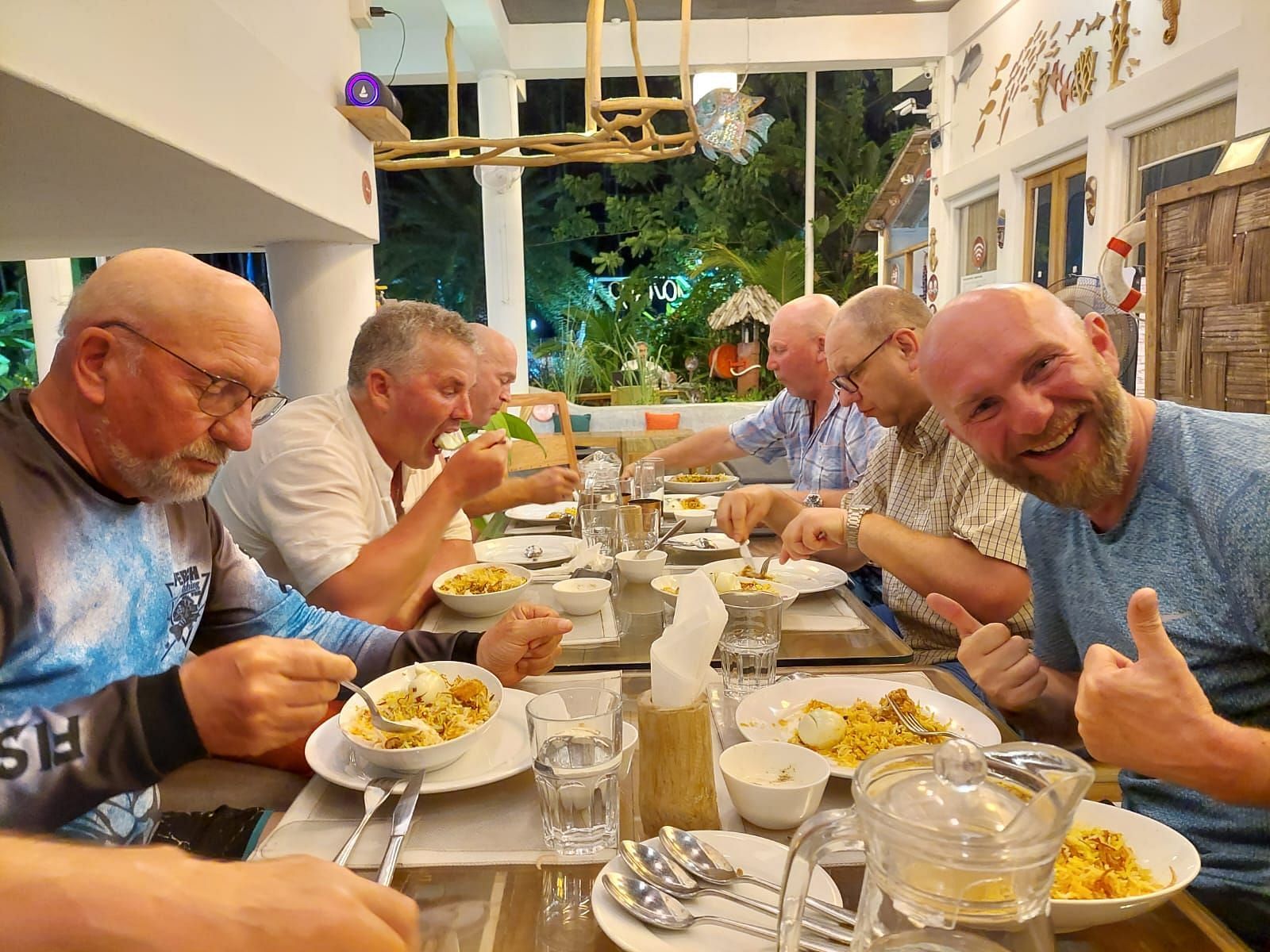 A side shot of multiple people having food at a dining table