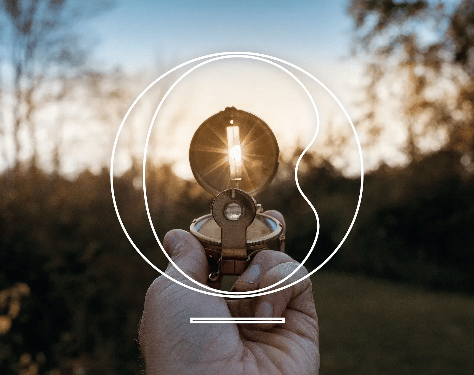 Close up image of a compass with a beautiful jungle landscape in the background.