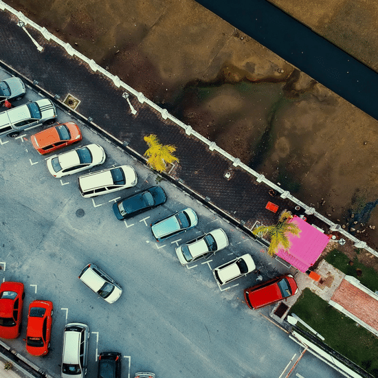 An aeriel view of a bunch of cars parked parallel