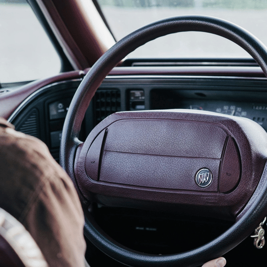 A steering wheel of a car shot up close