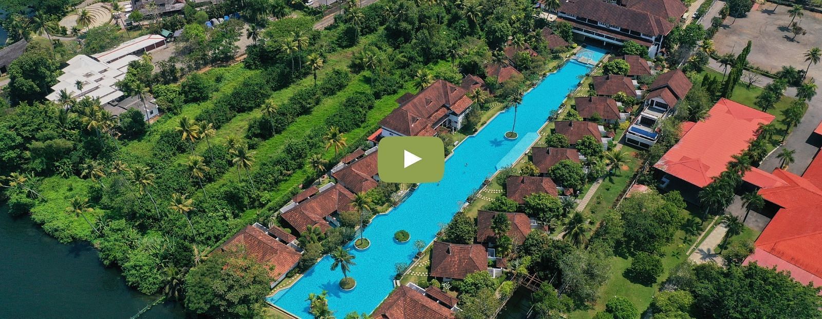 bird's eye view of a swimming pool with rooms and trees in view - Rhythm Kumarakom