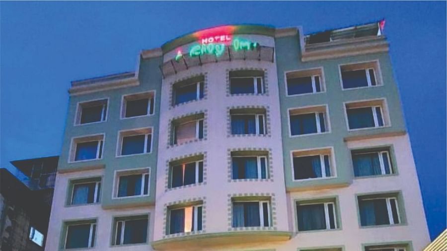  Night-time view of Hotel City Inn, Varanasi, illuminated with colourful lighting, displaying contact details prominently.