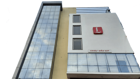A tall, modern building with a sign and a glass exterior.