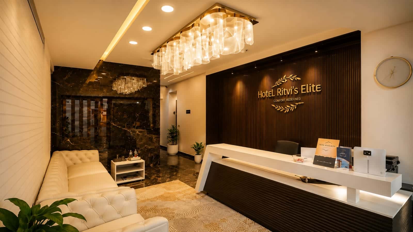 Reception at Hotel Ritvi's Elite in the evening, the marble-topped desk lit beneath the cluster chandelier